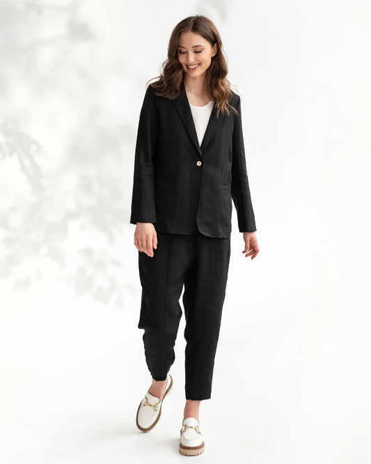 Modellen bär en svart linneblazer och svarta linnebyxor.