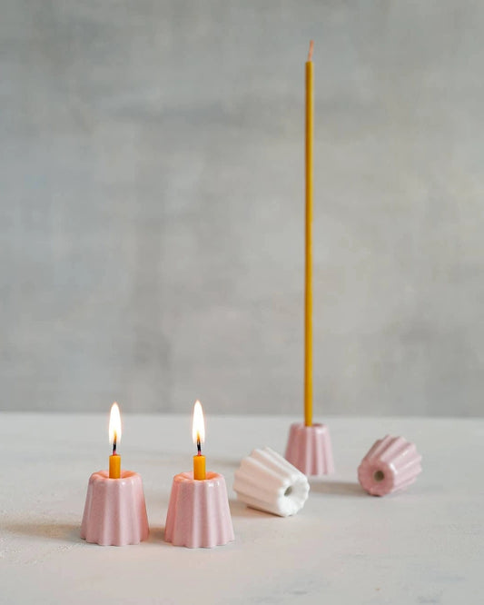 Små keramikljusstakar i rosa och vitt.