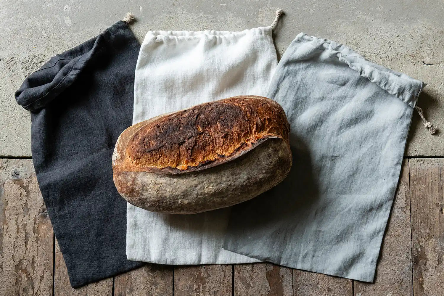 Tre brödpåsar och ett surdegsbröd 