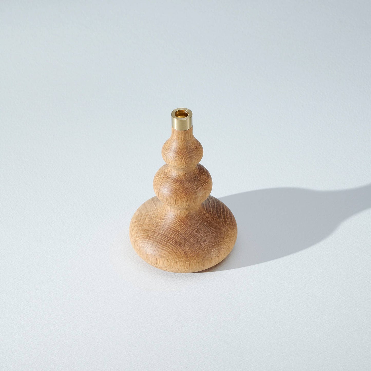 En rund formad ljusstake i ek