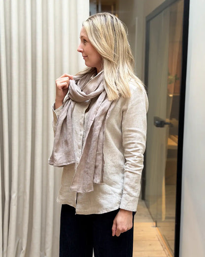 En naturfärgad linnesjal på en kvinna med beige linneskjorta 