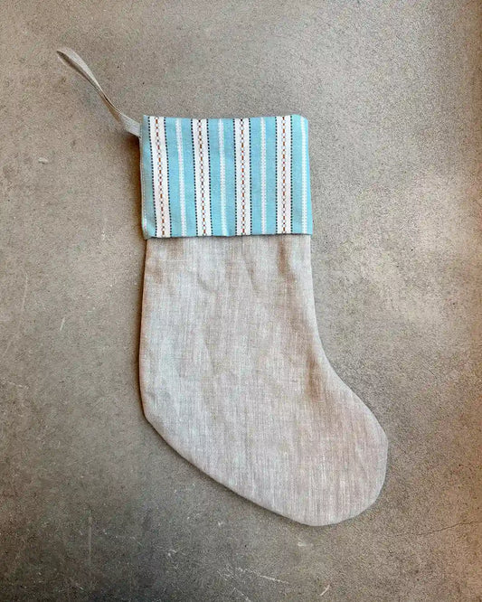 En beige julstrumpa med blå kant