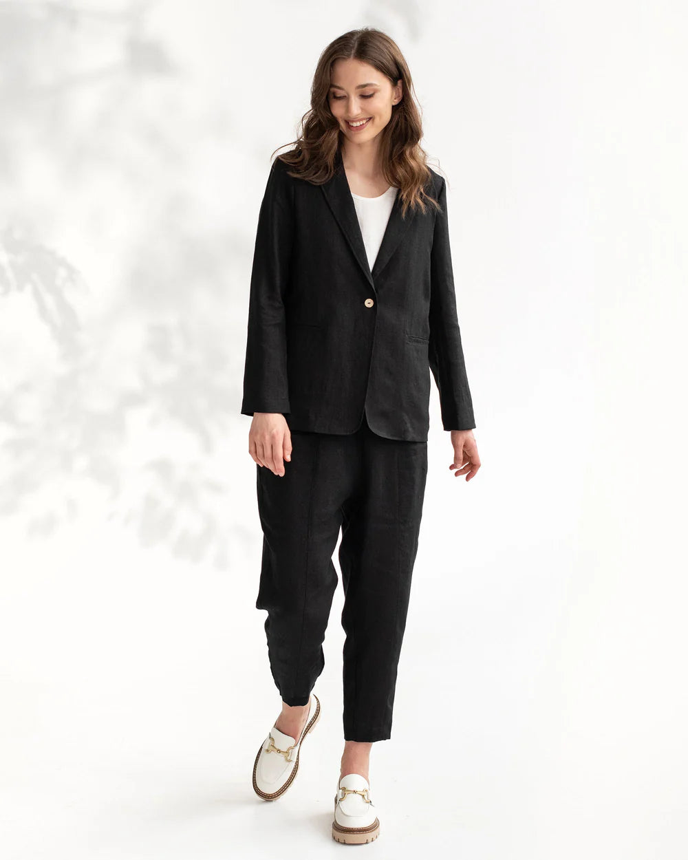 Modellen bär en svart linneblazer och svarta linnebyxor.