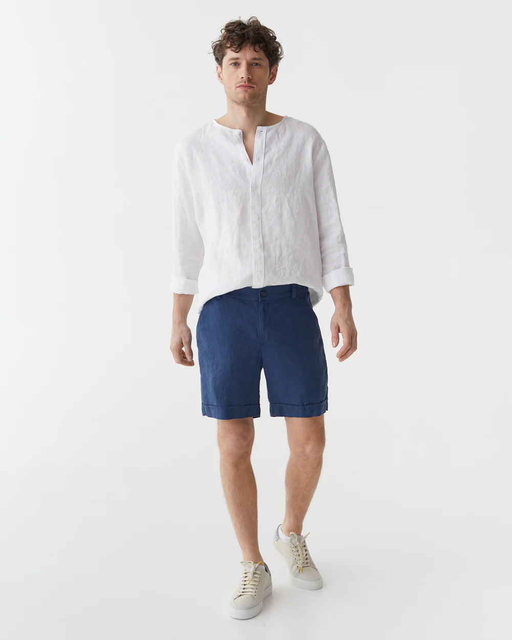 Blåa linneshorts och vit linneskjorta på en man 