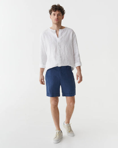 Blåa linneshorts och vit linneskjorta på en man 