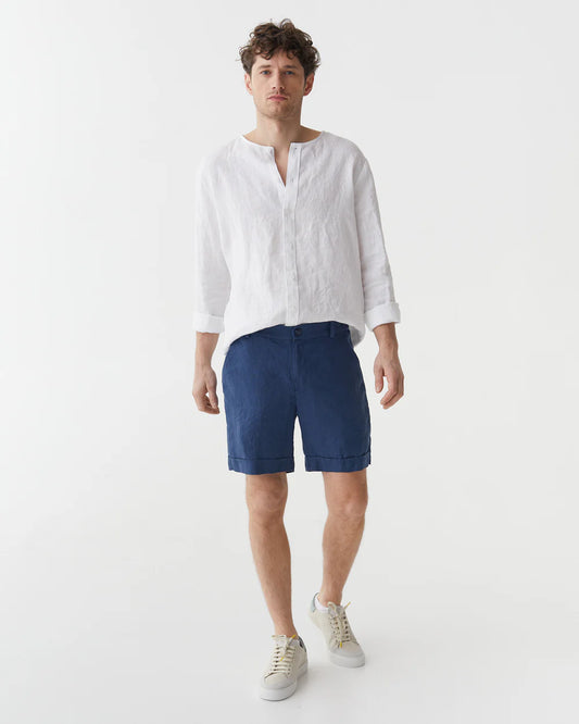 Blåa linneshorts och vit linneskjorta på en man 