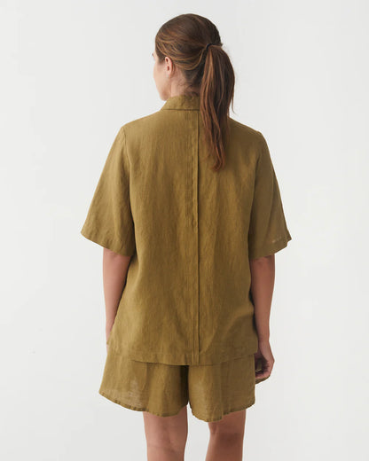 En olivgrön linneblus med korta armar och linneshorts 
