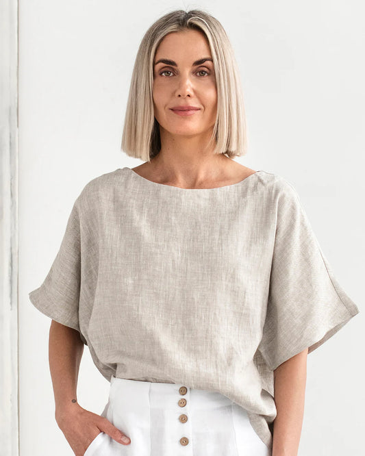 En kortärmad beige linneblus och vita linnebyxor