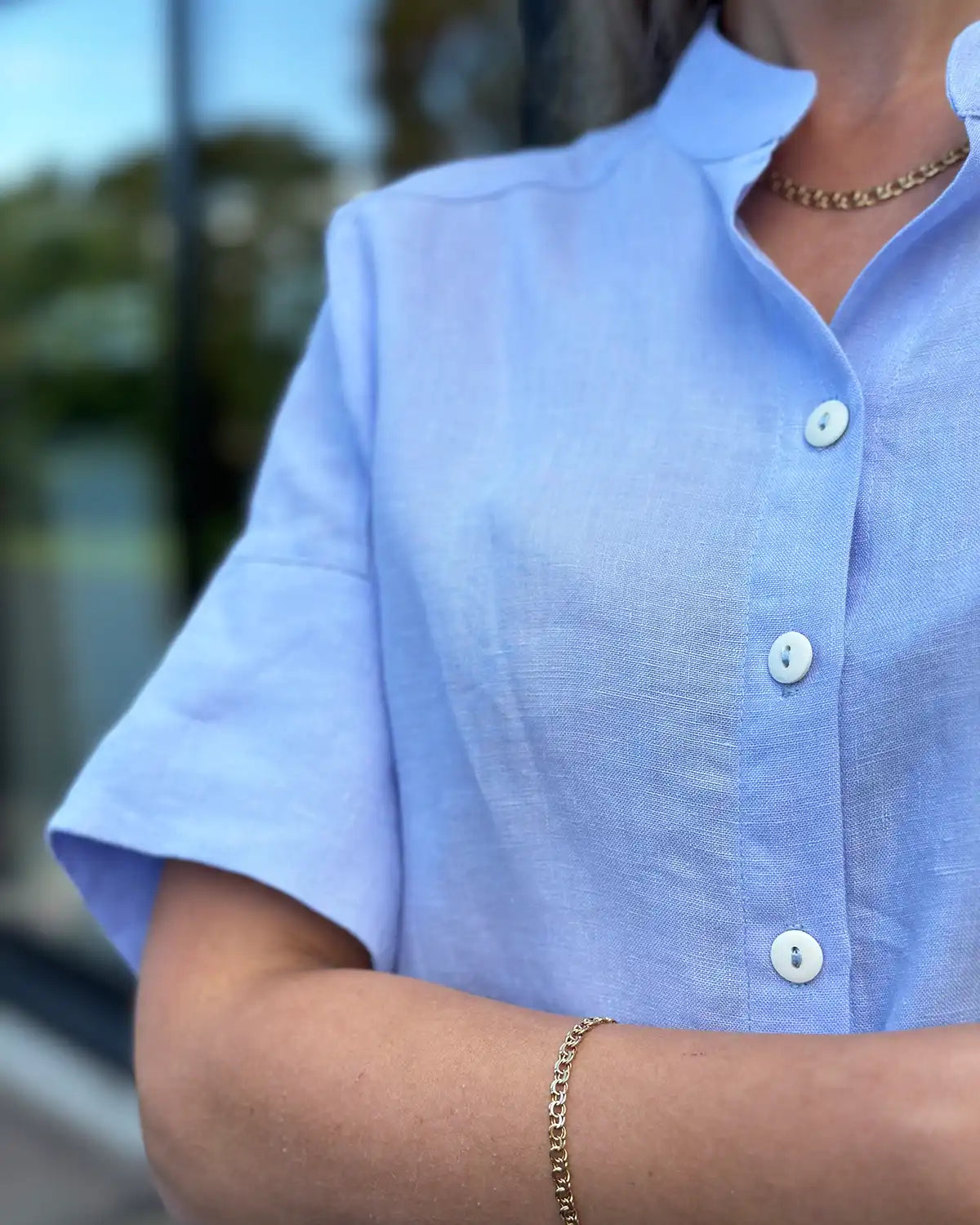 En ljusblå blus med knappar och krage 