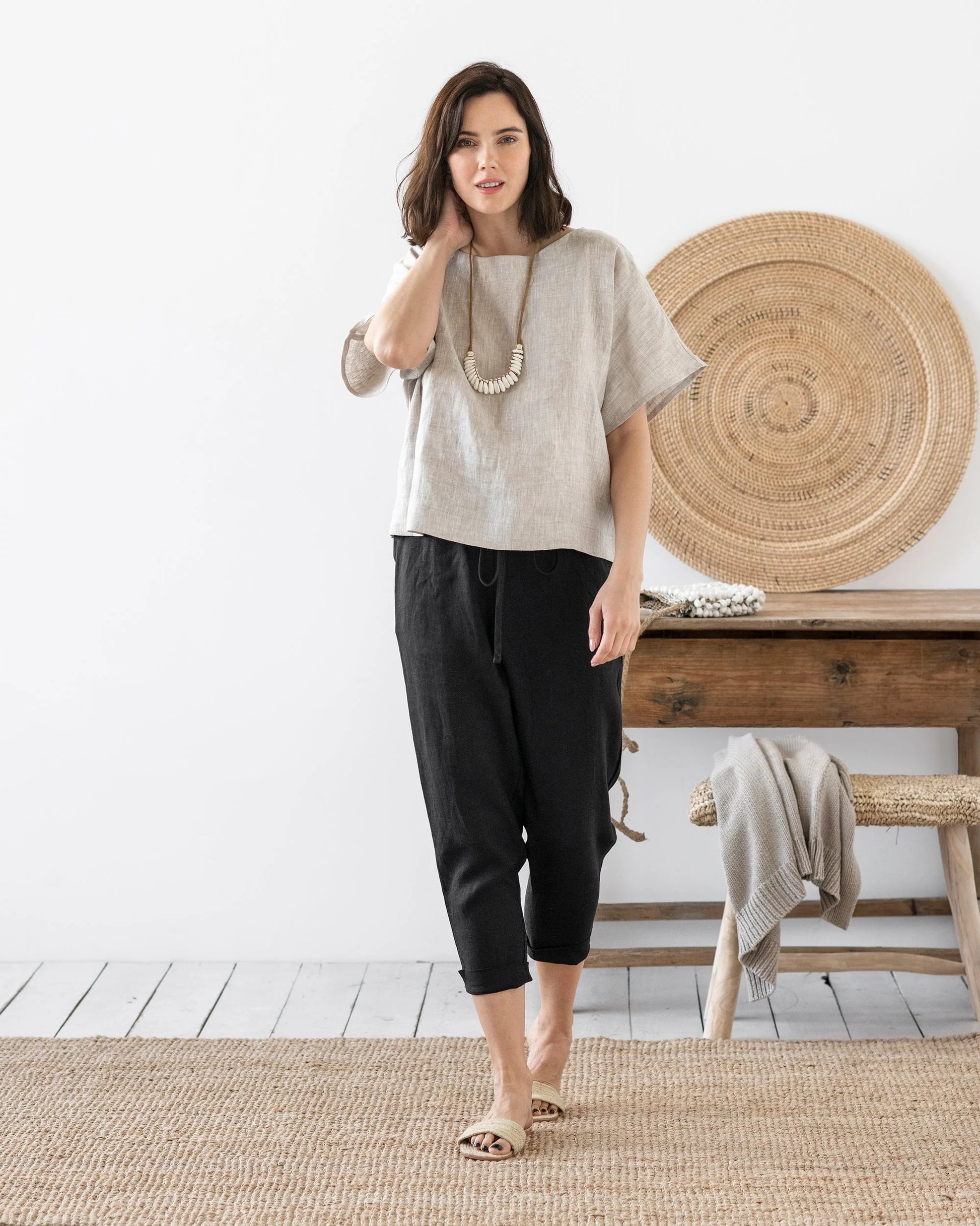 Svarta linnebyxor och en beige linneblus