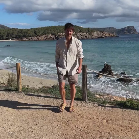 En film på en man som bär linneshorts och en linneskjorta 