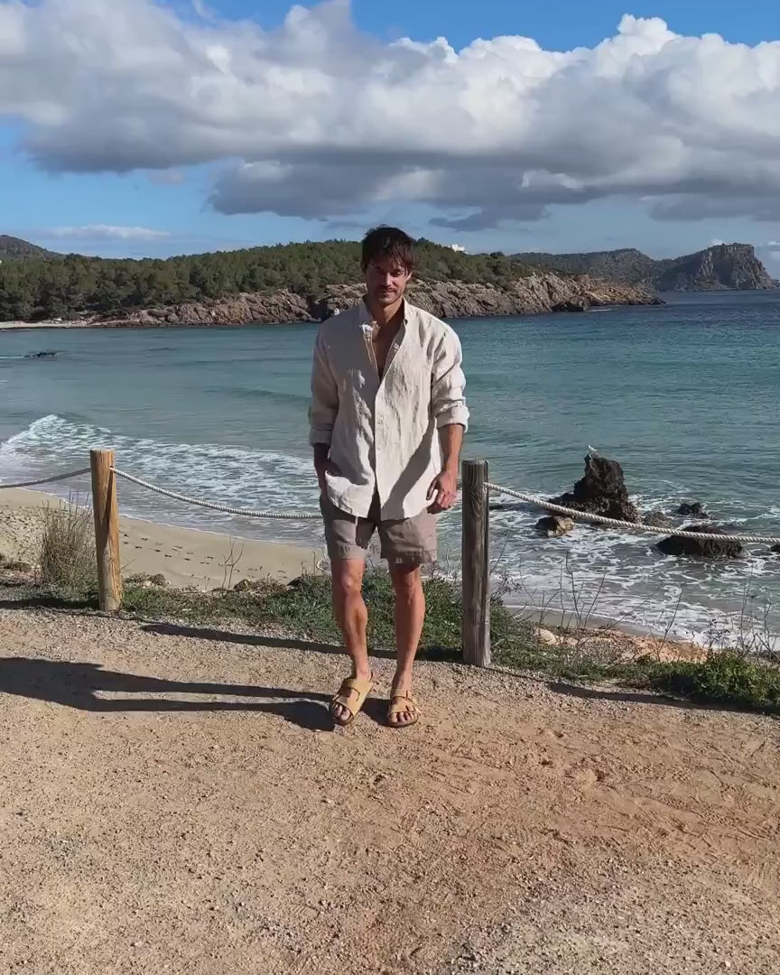 En film på en man som bär linneshorts och en linneskjorta 