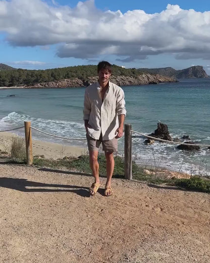 En film på en man som bär linneshorts och en linneskjorta 