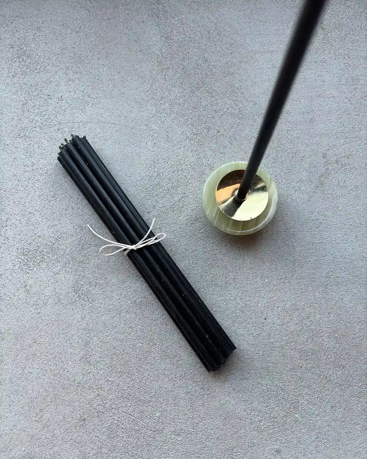 svarta bivaxljus och en liten marmorljusstake 