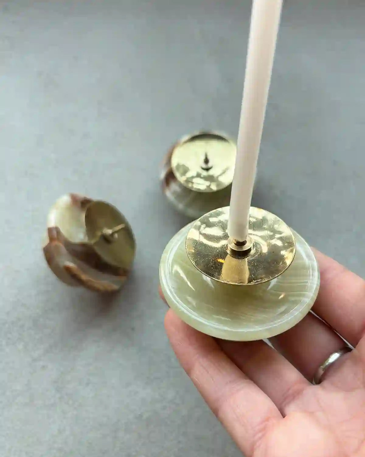 En ljusstake i marmor med ett vitt bivaxljus