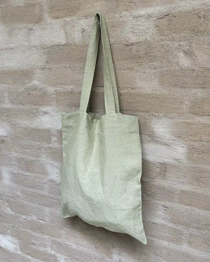 En påse i tyg med axellånga handtag 