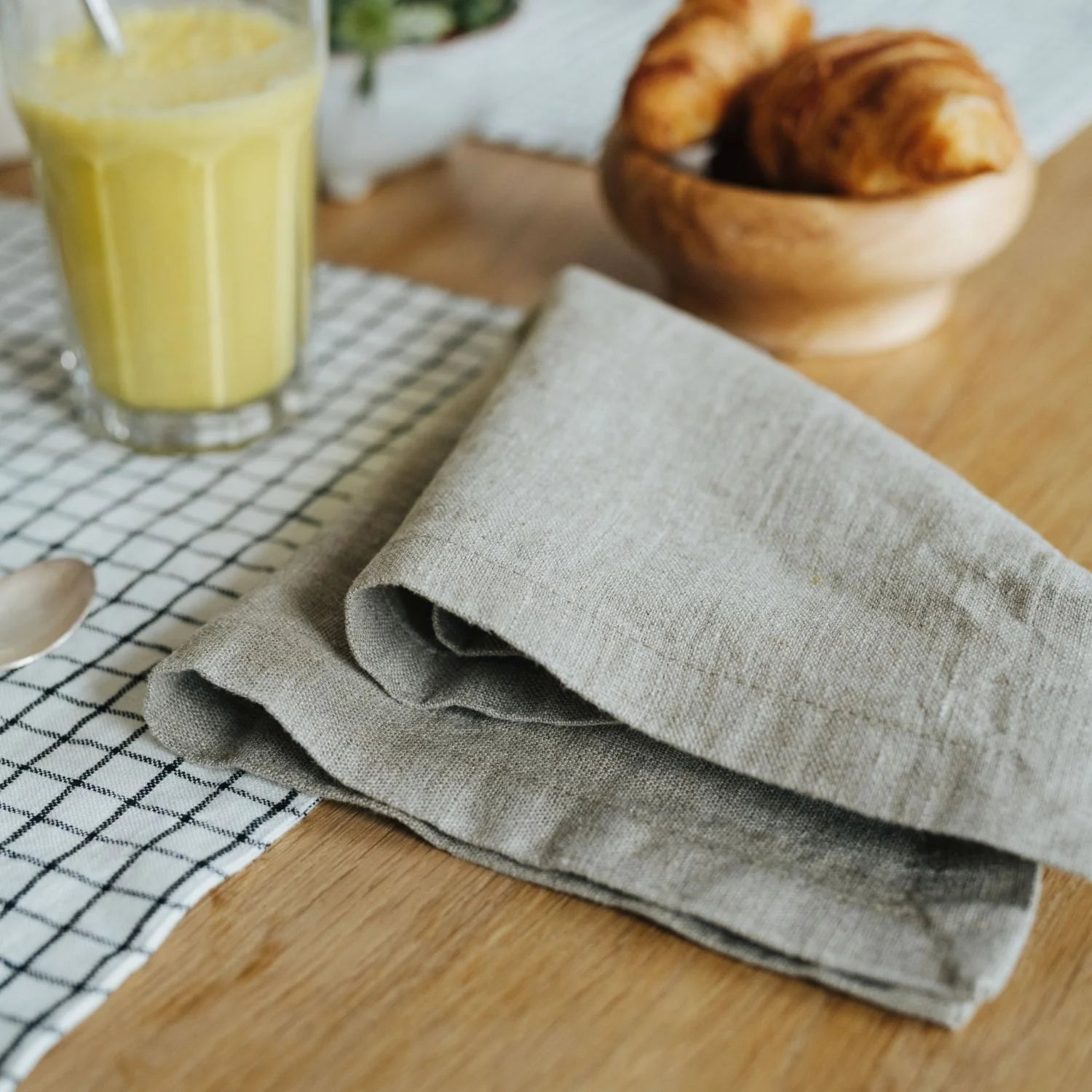 En vikt linneservett ligger på ett dukat bord.