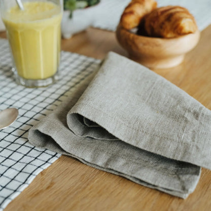 En vikt linneservett ligger på ett dukat bord.