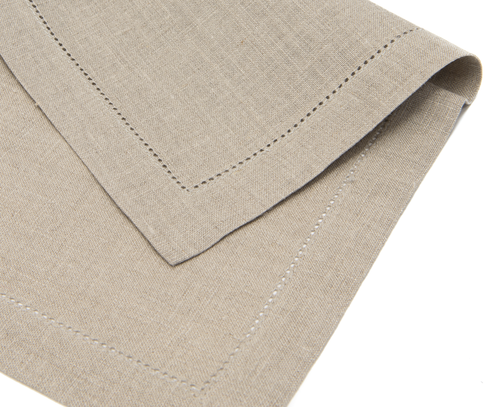 En beige linneservett med hålsöm ligger vikt på mitten. 